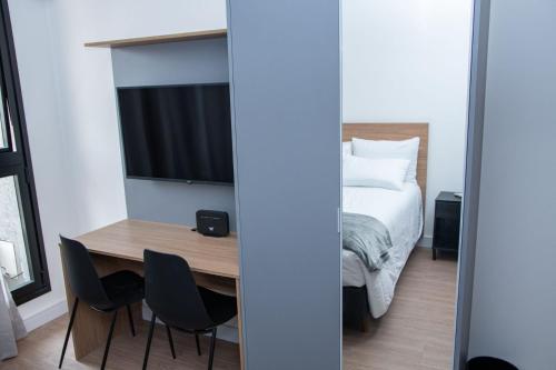 a bedroom with a bed and a table and chairs at ST Studios Vila Mariana by Housi in Sao Paulo