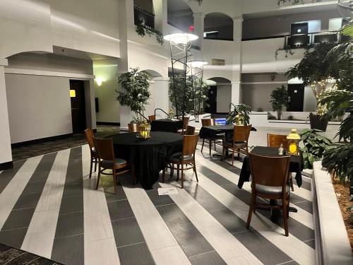 a dining room with tables and chairs and plants at Holiday Inn & Suites Springfield-I-44 by IHG in Springfield