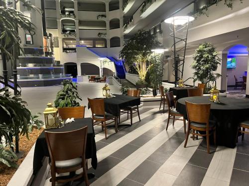 a restaurant with tables and chairs and potted plants at Holiday Inn & Suites Springfield-I-44 by IHG in Springfield