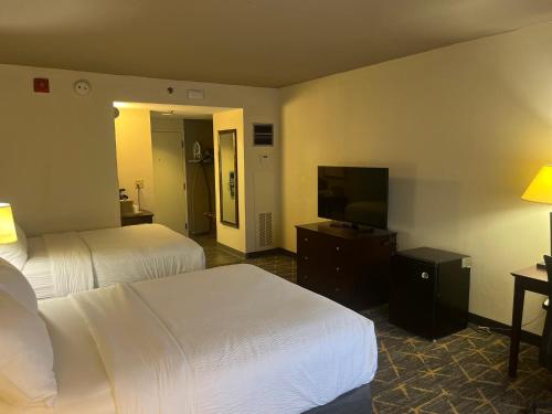 a hotel room with two beds and a flat screen tv at Holiday Inn & Suites Springfield-I-44 by IHG in Springfield