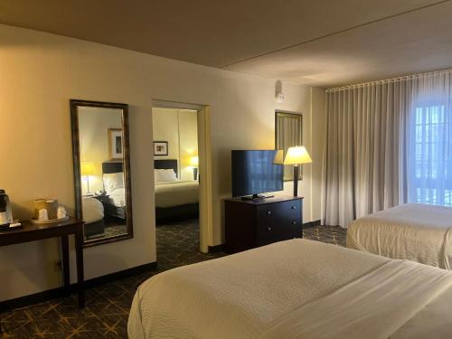 a hotel room with two beds and a mirror at Holiday Inn & Suites Springfield-I-44 by IHG in Springfield