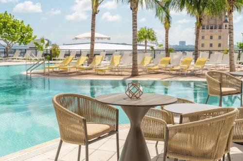 a table and chairs next to a swimming pool at Miami Luxe Escape Best High Waterfront Views, City Lights, Pool, Spa Amazing location in Miami