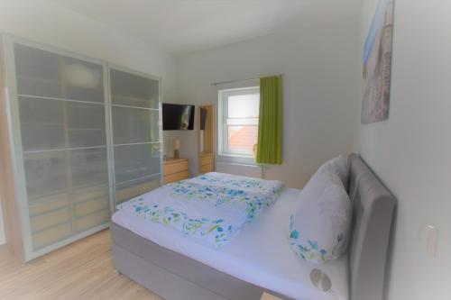 a small bedroom with a bed and a window at Urlaubsdomizil InselLust-Rügen in Sassnitz
