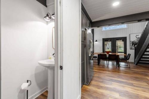 a kitchen and dining room with a sink and a refrigerator at NEW Toccoa River Front - HotTub Fire pit Game Room in Mineral Bluff