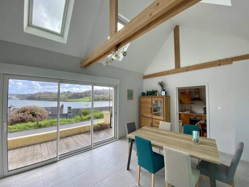 une salle à manger avec une table et une grande fenêtre dans l'établissement Locquenole - maison avec vue mer, à Locquénolé