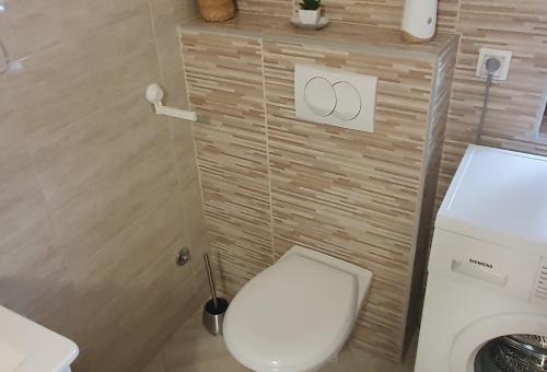 a bathroom with a toilet and a washing machine at Ada mall-Beograd 2 bedroom in Čukarica