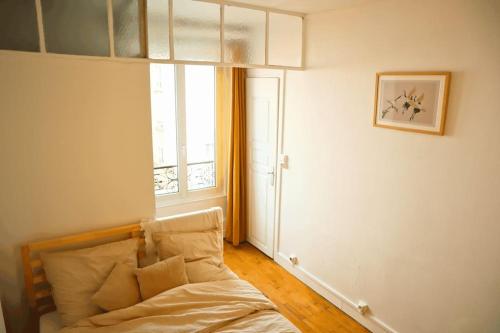 - une chambre avec un lit et une fenêtre dans l'établissement Grand T2 Élégant à Nation, Paris, à Paris
