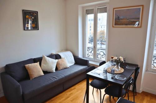 un salon avec un canapé bleu et une table dans l'établissement Grand T2 Élégant à Nation, Paris, à Paris