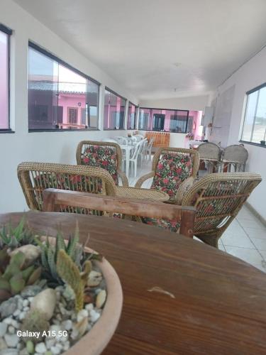 a room with chairs and tables and a table with a cactus at Recanto Pequena Sereia in São Mateus