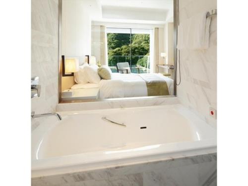 a bath tub in a bathroom with a bedroom at Olive Bay Hotel - Vacation STAY 75564v in Saikai