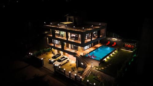 a large building with a swimming pool at night at Dolce Villa IGATPURI in Igatpuri