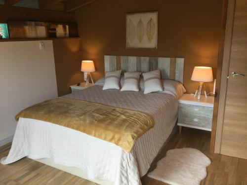 a bedroom with a large bed with two night stands at Casa Jardín Rocablanca Llanes in Celorio