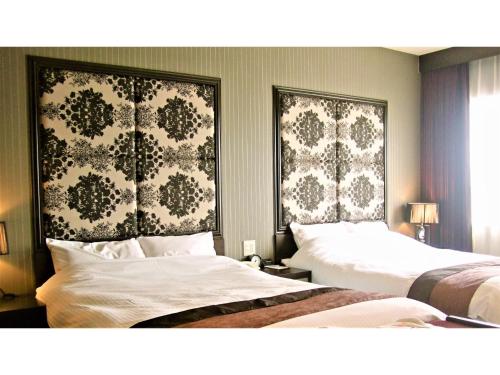 two beds in a hotel room with wallpaper at TSUYAMA KAKUZAN HOTEL - Vacation STAY 75710v in Tuyama