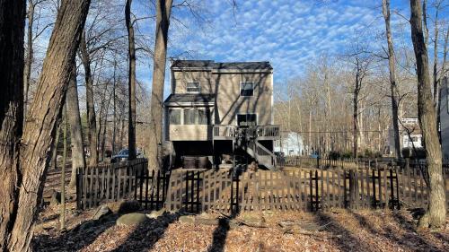 an old house in the woods behind a fence at Poconos Modern Chalet-Hot Tub-Home Theater-Lake in East Stroudsburg