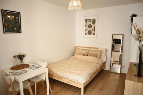 une petite chambre avec un lit et une table dans l'établissement Cocon Moderne à Nation, Paris, à Paris