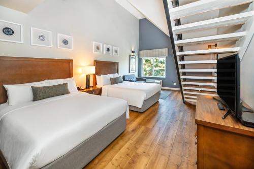a bedroom with two beds and a staircase at Banff Inn in Banff
