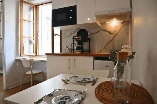 une cuisine avec une table et un vase dans l'établissement Cocon Moderne à Nation, Paris, à Paris