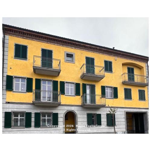 un gran edificio amarillo con balcones. en appartamento dolcevita, en Alba