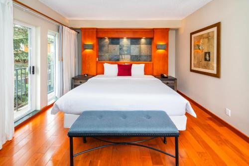 a bedroom with a large white bed and two windows at Banff Inn in Banff