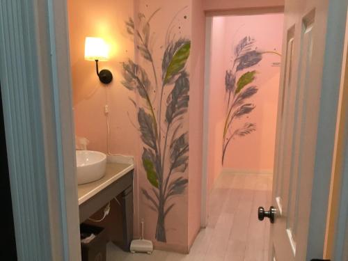 un baño con una pintura en la pared junto a un lavabo en Second floor - Vacation STAY 83098v, en Naha