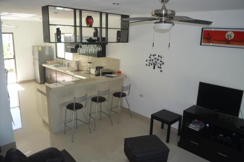 a kitchen with a counter and bar with stools at Casa Mango in Valladolid