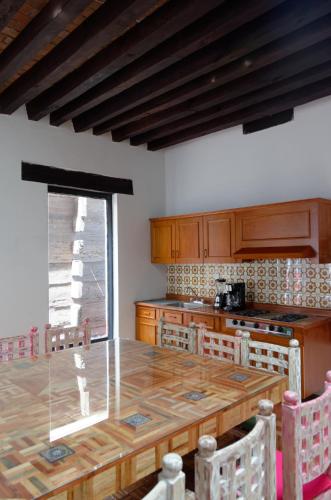 a kitchen with a large wooden table with chairs at troje tradicional purépecha -live the experince- in Morelia
