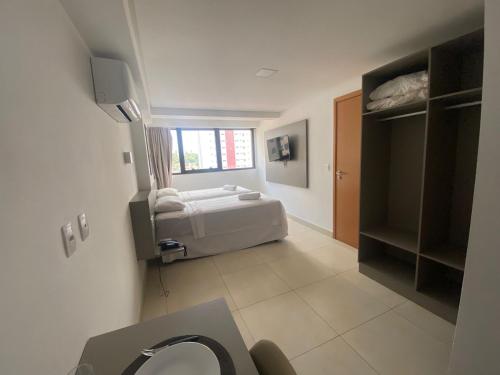 a bathroom with a bed in a room at Guest Manaíra Apart Hotel in João Pessoa