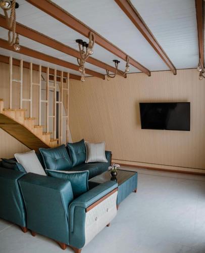 a living room with a couch and a tv at Haven A frame Shahdag in Qusar