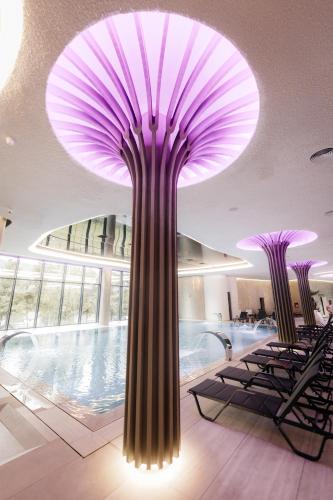 a large purple chandelier in a building with a pool at Hotel Ivascu in Moisei