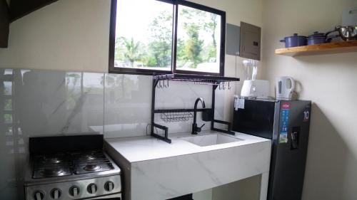 a kitchen with a sink and a stove and a window at Divan Eco Lodge in Fortuna