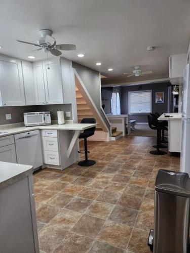 a kitchen with white cabinets and a tile floor at Sandusky Boathouse with view of Cedar Point in Sandusky