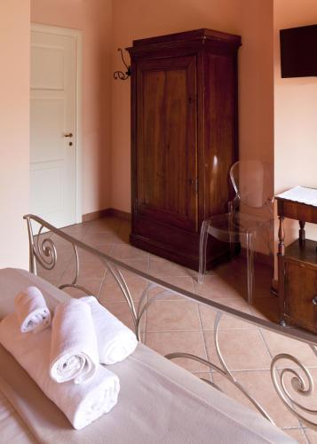 a bedroom with a bed and a wooden cabinet and towels at La Corte D'Emilio B&B in Vignola