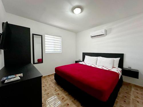 a bedroom with a bed with a red blanket at Ladybugs Apartments in Palm-Eagle Beach
