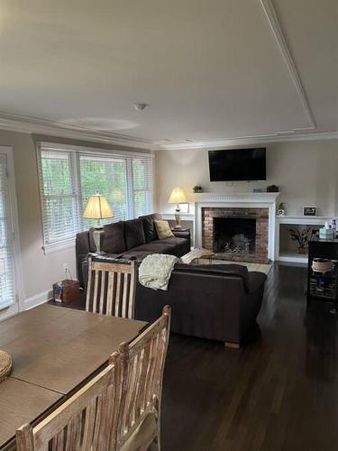 a living room with a couch and a fireplace at Amazing Location - Walk Across To North Hills in Raleigh