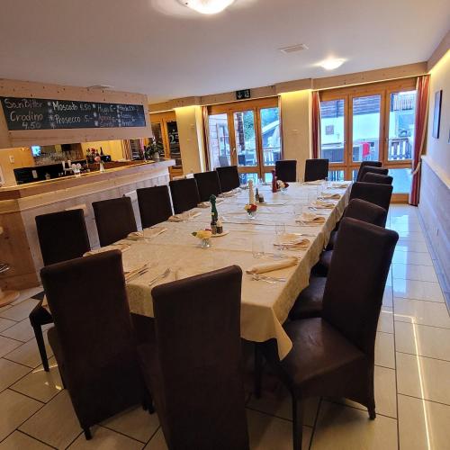 a long dining room with a long table and chairs at Residence Edelweiss No Stress by Eva in Bellwald