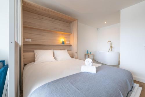 une chambre avec un grand lit et un lavabo dans l'établissement Bulles de la Marina - Balnéo, à Capbreton