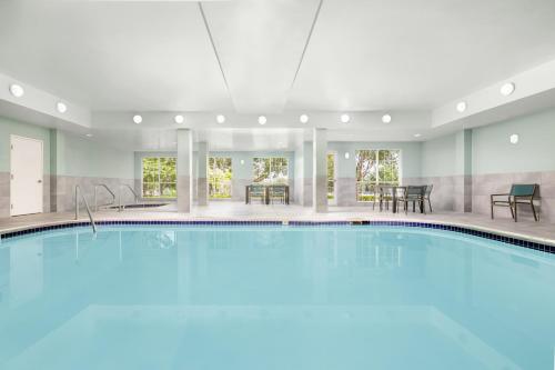 a pool in a hotel with tables and chairs at Homewood Suites by Hilton Dallas-DFW Airport N-Grapevine in Grapevine