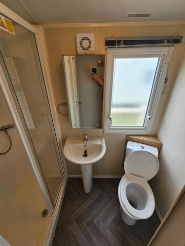 a small bathroom with a toilet and a sink at Doc's Cave in Mablethorpe
