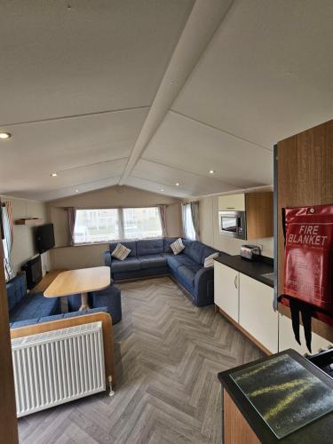a living room with a couch and a table at Doc's Cave in Mablethorpe