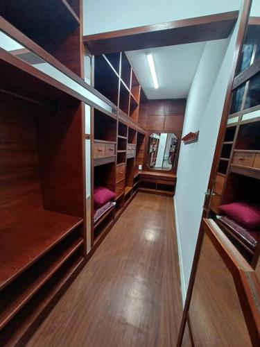an empty room with wooden shelves and wooden floors at Apartamento vista montanha in Gravatal
