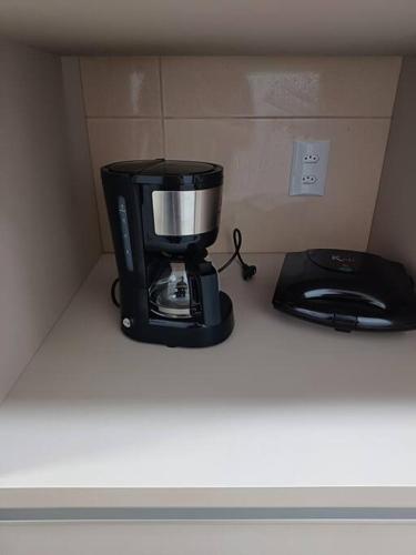 a coffee maker sitting on a counter next to a blender at Apartamento vista montanha in Gravatal