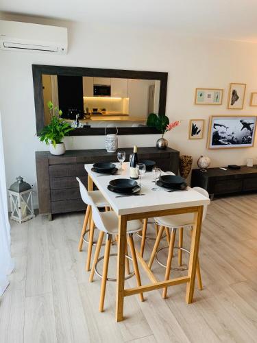 une salle à manger avec une table et des chaises blanches dans l'établissement Appartement T3 de 60 M2 dans quartier calme, au Teich