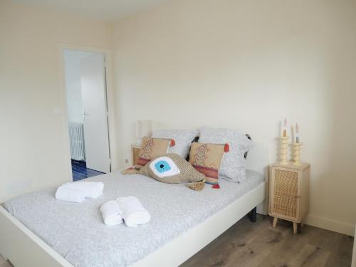 a bedroom with a bed with towels and a mirror at L'échappée Deauvillaise - Entièrement Rénové en 2025 in Deauville