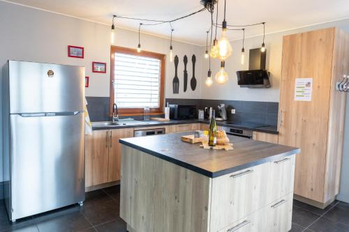 une cuisine avec un réfrigérateur en acier inoxydable et des armoires en bois dans l'établissement Agréable maison à la campagne, à Schlierbach