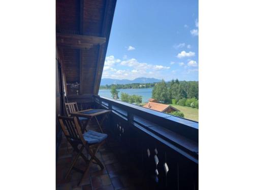 a balcony with chairs and a view of a lake at Holiday apartment Bräu in Riegsee