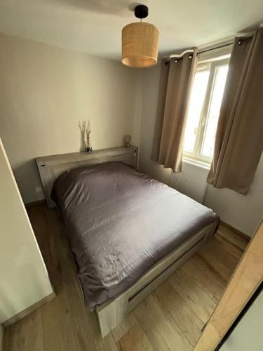 un lit assis dans une pièce avec une fenêtre dans l'établissement Logement cosy hyper centre, à Dunkerque