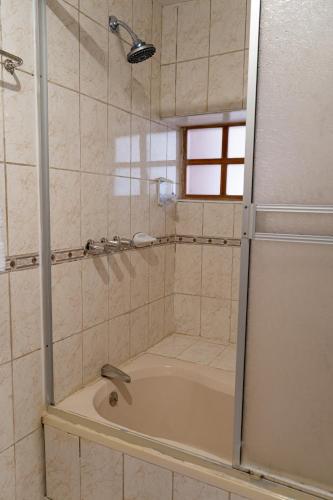 a bathroom with a shower and a bath tub at Hotel La Posada de Atahualpa in Cusco
