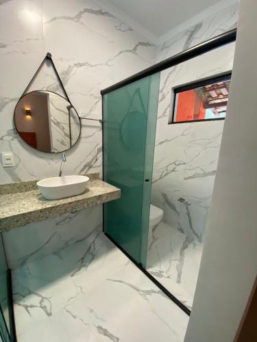a bathroom with a sink and a mirror at Pousada Cigarras da Serra in Serra do Cipo