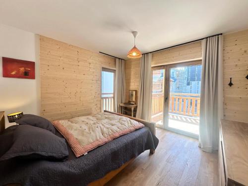 a bedroom with a bed and a large window at Résidence Le Living Stone B - LE LIVING STONE-Tout inclus MAE-1811 in Vars