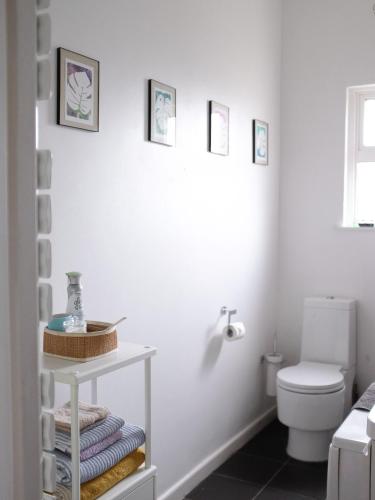a bathroom with a toilet and a shelf with towels at Penthouse Seaview Warrior Square in Hollington